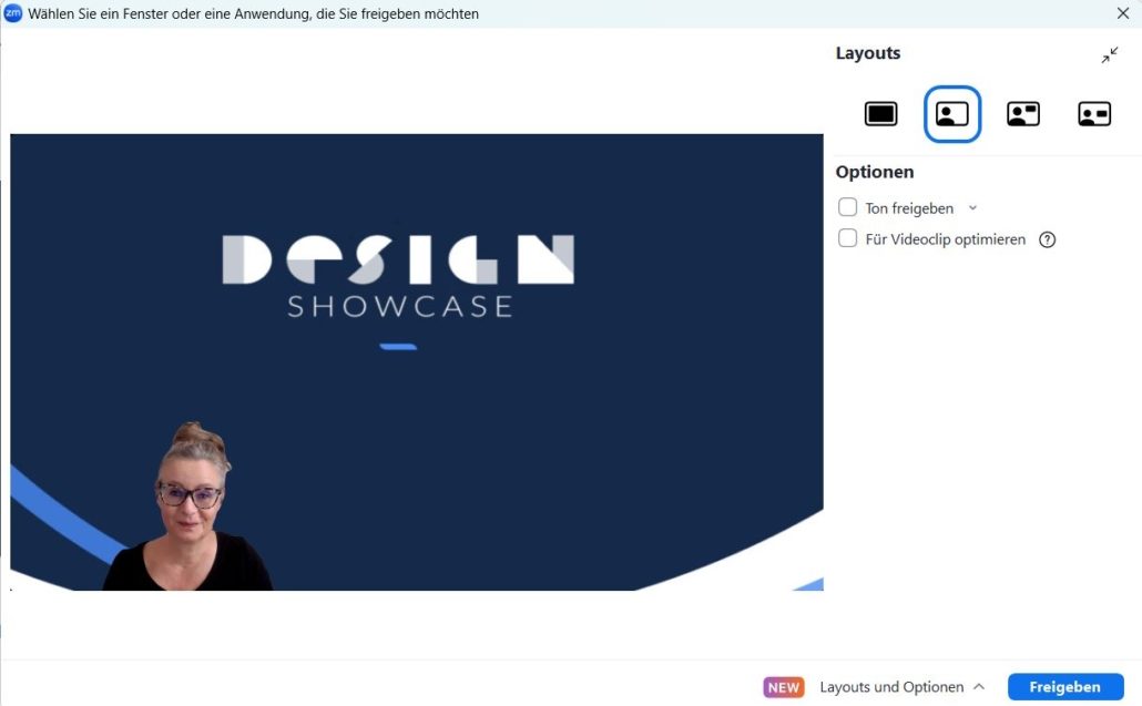 Ein Screenshot einer Zoom Bildschirm-Teilen-Oberfläche in deutscher Sprache zeigt ein "Design Showcase"-Dia. In der unteren linken Ecke ist eine Frau mit Brille zu sehen, und auf der rechten Seite des Bildschirms werden Freigabe- und Layout-Optionen angezeigt.